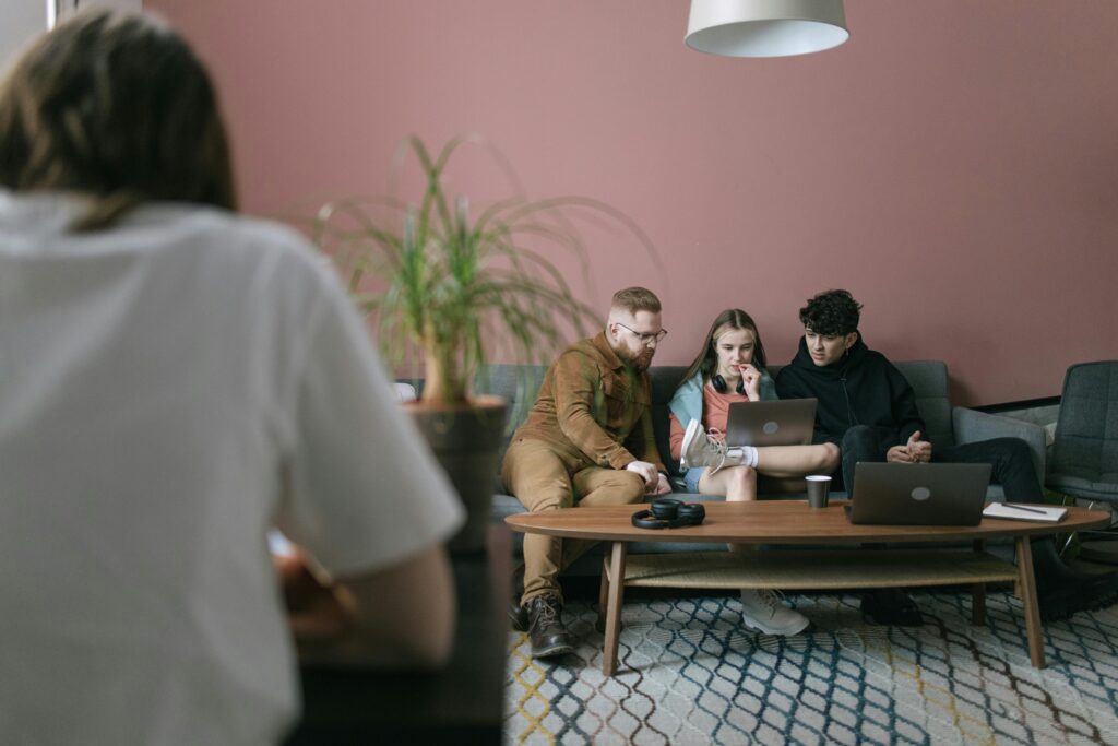 A diverse group of young professionals collaborating on a project in a contemporary office setting.